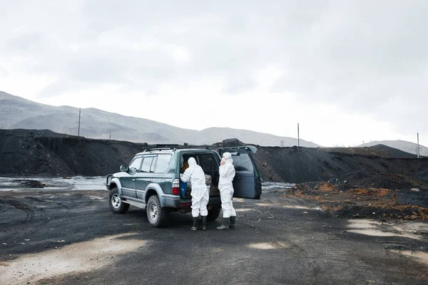 身穿防护服的环境工程师们站在救援车旁 用敞着的行李箱和卸货工具为土地整治作准备 — 图库照片