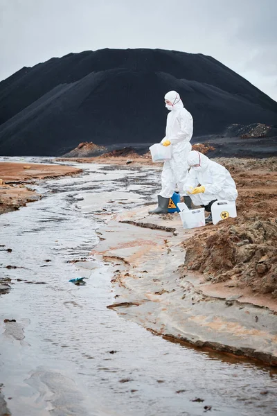 Fehér Védőruhát Maszkot Viselő Ökológusok Konténerekben Miközben Szennyezett Folyóból Vesznek — Stock Fotó