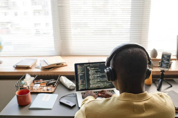Hátsó Nézet Fekete Férfi Vezeték Nélküli Fejhallgató Gépelés Laptopon Miközben — Stock Fotó