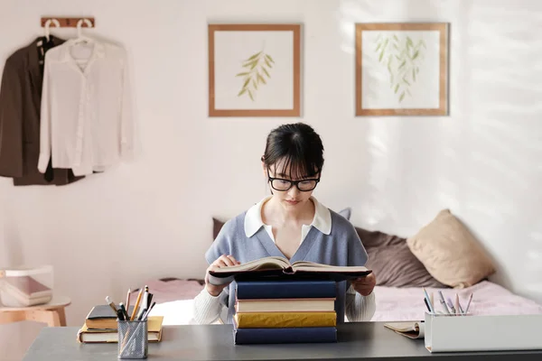 Skoncentrowany Azji Student Dziewczyna Okularach Siedzi Przy Stole Czytania Podręcznika — Zdjęcie stockowe