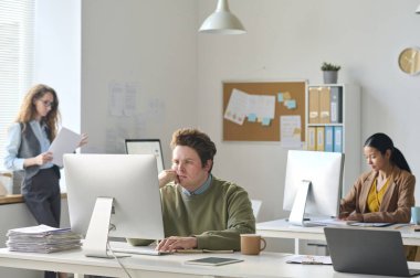 Modern ofisteki işyerlerinde çalışan bir grup iş arkadaşı