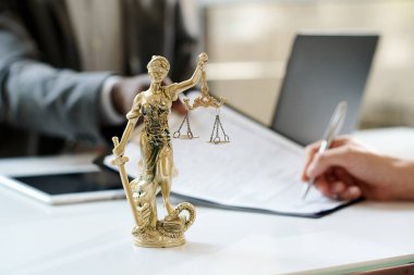 Adalet Tanrıçası 'nın yakın plan resmi. Ofisteki avukatın işyerine dayanıyor.