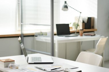 Modern taşınabilir bilgisayar, açık uzay ofisindeki ofis masasında dokümanları olan pano.