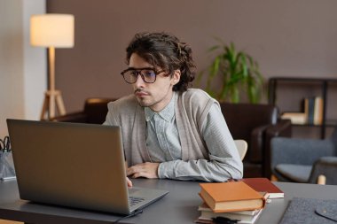 Modern profesyonel psikoloğun yatay görüntüsü. Ofisinde oturmuş hastasını beklerken internette sörf yapıyor.