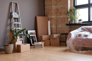 Yatay olarak, modern apartmandaki boş çatı katında hiç kimse çekilemez. Kutular, kanepe ve merdiven.