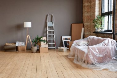 Yatay olarak, modern apartmandaki boş, ferah bir çatı katında çekilen hiç kimse, kutular, merdiven, kanepe ve çeşitli eşyalarla çekilmez.