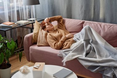 Yatay yüksek açı görüntüsü olan bir kadın evinde gözleri kapalı yatarken ateş ve baş ağrısı çekiyor.