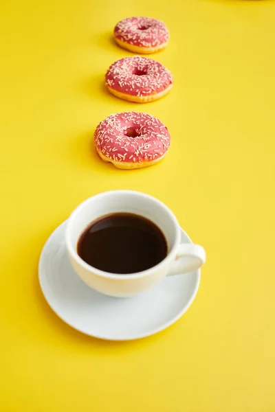 Ceramic Cup Black Coffee Sweet Doughnuts Row Yellow Background — Stock Photo, Image