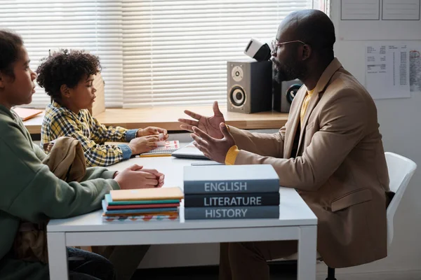 Afroameričtí Učitelé Vést Rozhovor Školními Dětmi Zatímco Oni Sedí Stolu — Stock fotografie