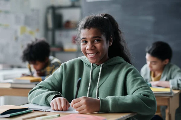 Portrét Afroamerické Školačky Usmívající Kameru Sedící Stolem Knihami Během Lekce — Stock fotografie