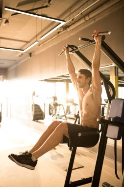 Spor kulübünde spor aletleri üzerinde barfiks çeken yakışıklı bir sporcu.