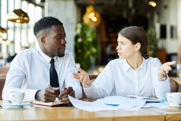Verwirrte Junge Multiethnische Geschäftskollegen Weißen Hemden Sitzen Tisch Und Diskutieren — Stockfoto