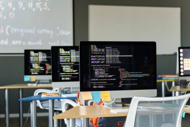 Bilgisayarlar sıralarda kodlar ve monitörler okulda bilgi işlem için.