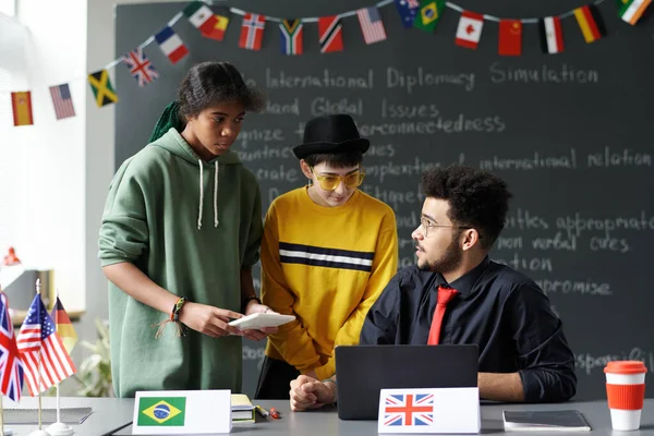 stock image Students talking to teacher in the classroom after lesson, they discussing material together