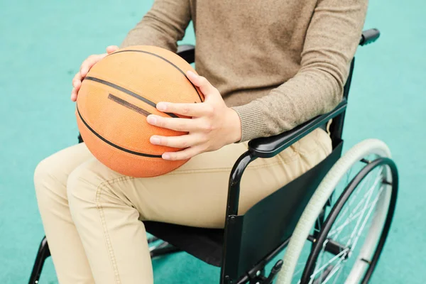 Крупный План Неузнаваемого Баскетболиста Свитере Сидящего Инвалидном Кресле Держащего Мяч — стоковое фото