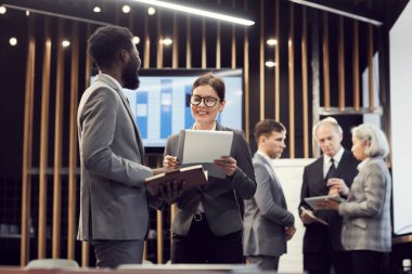 Formalite icabı iş arkadaşları toplantı odasında dikilip satış sonuçlarını araştırıyorlar.