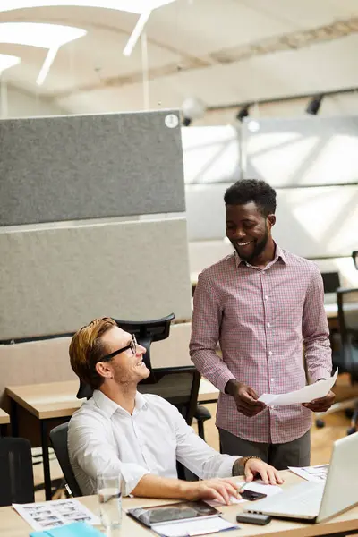 Takım halinde çalışan ve dijital proje için tasarım seçen neşeli, yaratıcı, çok ırklı genç erkekler.