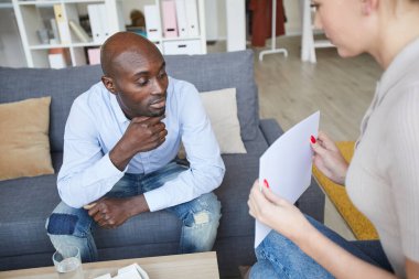 Kadın psikanalist, düşünceli siyahi bir hastaya resimler gösteriyor ve terapi seansında gördüklerini tarif etmek istiyor.