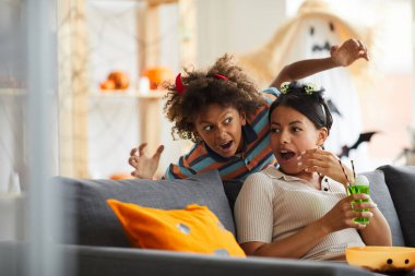 Kırmızı boynuzlu Afro-Amerikan evladı, annesi kanepede oturup ağzını açarken korkudan tir tir titriyor.