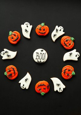 Cadılar Bayramı 'nın çemberi, yuvarlak şekilli kurabiyelerin içinde yaratıcı çizgi film tasarımı ve yuvarlak şekilli ve üzerinde yazı olan kurabiyeler.