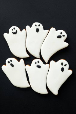 Siyah arka planda komik suratları olan hayalet kurabiyeleri seti, Cadılar Bayramı yemeği konsepti