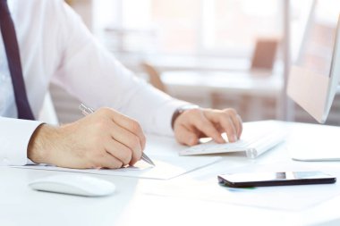 Beyaz masada oturan tanınmayan işadamlarının yakın plan fotoğrafları ve ofiste kontrat incelerken bilgisayar kullanmaları.