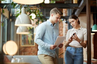 Mobil uygulamanın verimliliğini analiz ederken akıllı telefon kullanan düşünceli genç pazarlama ekibi