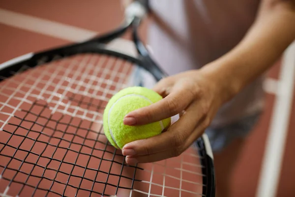 stock image Close-up of unrecognizable woman putting tennis ball on racket while carrying out effort of serving before match