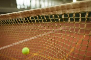 Tenis topunun hata için ağa vurduğu yakın plan, kapalı alanda tenis sahasına odaklan, boşluğu kopyala