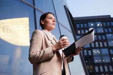 Finans bölgesinde kahve fincanı taşıyan ve yıllık toplantılara hazırlanan dalgın iş kadınlarının bakış açısının altında.