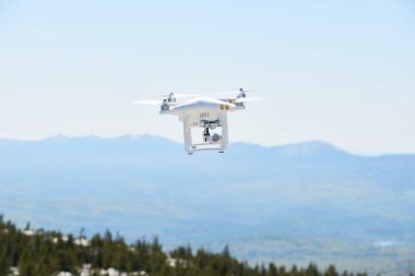 Kuadrokopterle havadan çekim yapıyorum. Güneşli bir günde dağların ve ormanların üzerinden uçan kameralı bir robot.