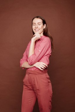 Gülümseyen, kaygısız, kahverengi saçlı, hayatın tadını çıkaran bir kadın.