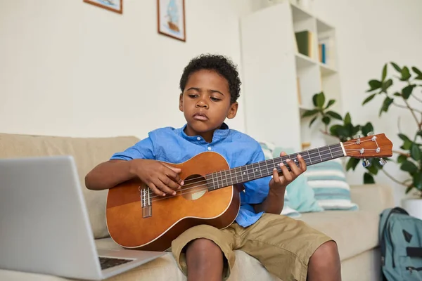 Oturma Odasında Kanepede Oturan Gitar Çalmayı Öğrenirken Online Video Izleyen — Stok fotoğraf