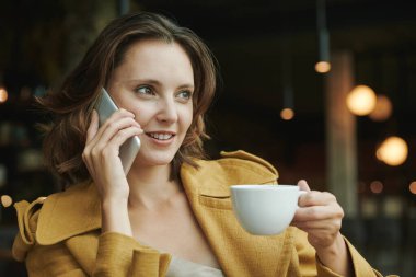 Kafedeki masada siyah kahve ve kruvasanın fotoğrafını çeken tanınmayan bir adamın manzarasının üstünde blogcular yaşam tarzı kavramına sahipler.