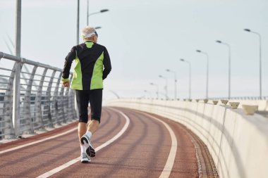 Siyah ve yeşil eşofman giyen yaşlı adamın yatay arka plan görüntüsü