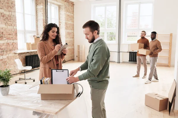 Smiling Young Woman Checking List While Her Colleague Unpacking Moving — Stock Photo, Image