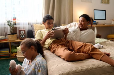 Afrika kökenli Amerikalı anneler, kızlarıyla odalarında oyun oynarken vakit geçiriyorlar.