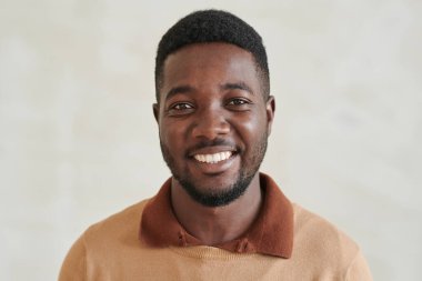 Sakallı, süveter giyen, yakışıklı, Afro-Amerikan bir adamın portresi.
