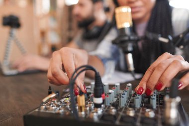 Arkadaşı dizüstü bilgisayardan bir şey izlerken modern kadın blog yazarının ses ayarlarını ayarlarken yatay yakın çekim görüntüsü.