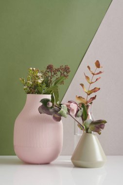 Beyaz ve yeşil arkaplana karşı vazolardaki güzel çiçeklerin modern yaşam kompozisyonu, kopyalama alanı