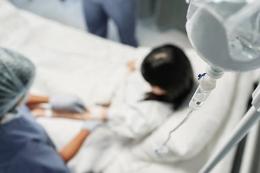 Yüksek açılı seçici odak noktası. Kadın hastanede damar içi terapi görüyor.