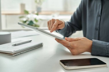 Tablet bilgisayar kullanan ve masada otururken online çalışan genç iş kadınlarının yakın plan fotoğrafları.