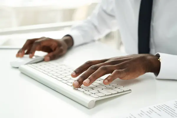 Close-up of African American businessman typing on computer keyboard at his workplace at office
