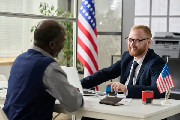 stock image Portrait of friendly smiling worker consulting senior black man in US immigration office