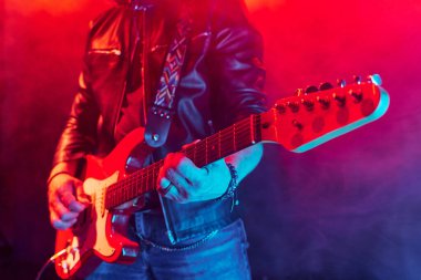 Elektro gitar çalan tanınmayan rock müzisyeninin ellerindeki boşluğu kopyalamaya odaklandığı yakın plan.