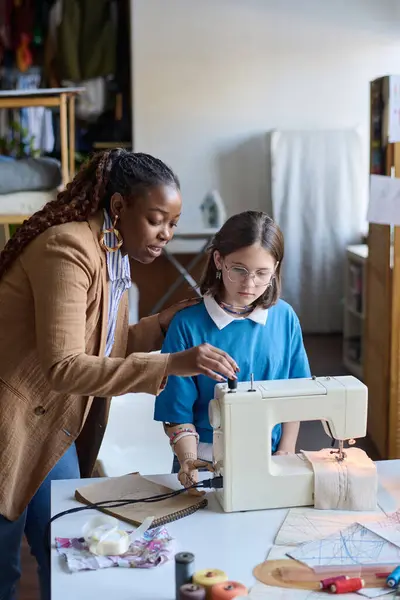Vertical portrait of African American woman teaching girl with disability using sewing machine in school classroom