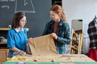 İki genç kızın portresi. Okuldaki terzilik sınıfında birlikte kıyafet dikiyorlar.