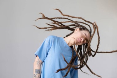 Dövmeli beyaz kadın portresi. Uzun, serbest saç stili, dans ve beyaz fotokopi alanı üzerinde hareket eden beyaz saçlı.