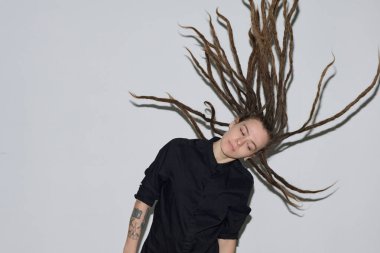 Özgür ruhlu beyaz kadın portresi. Uzun saçlı, beyaz arka planda dans eden, flaş fotokopi alanı olan beyaz saçlı.