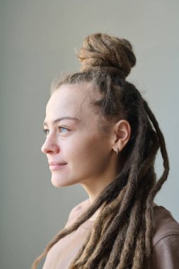 Kafkasyalı genç bir kadının dikey profil portresi. Uzun saçlı, yüzünde gülümseme, makyajsız.